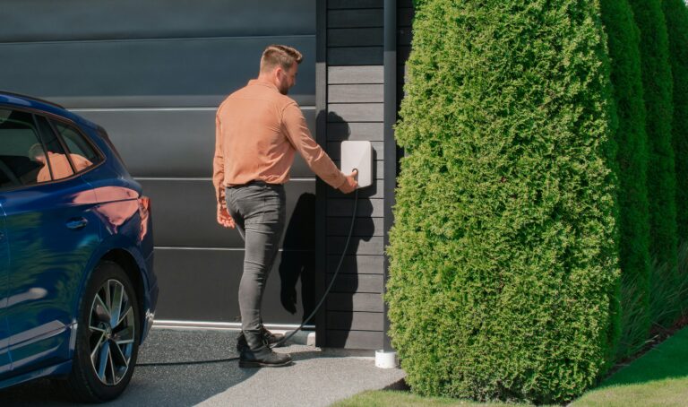 Close-up of an outdoor EV charging station installed beside a driveway