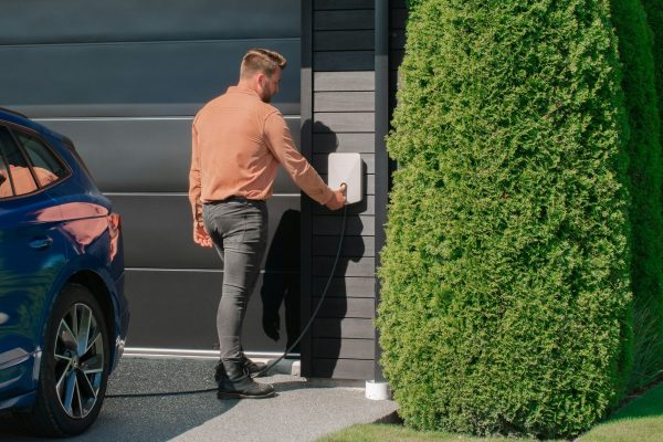 Close-up of an outdoor EV charging station installed beside a driveway